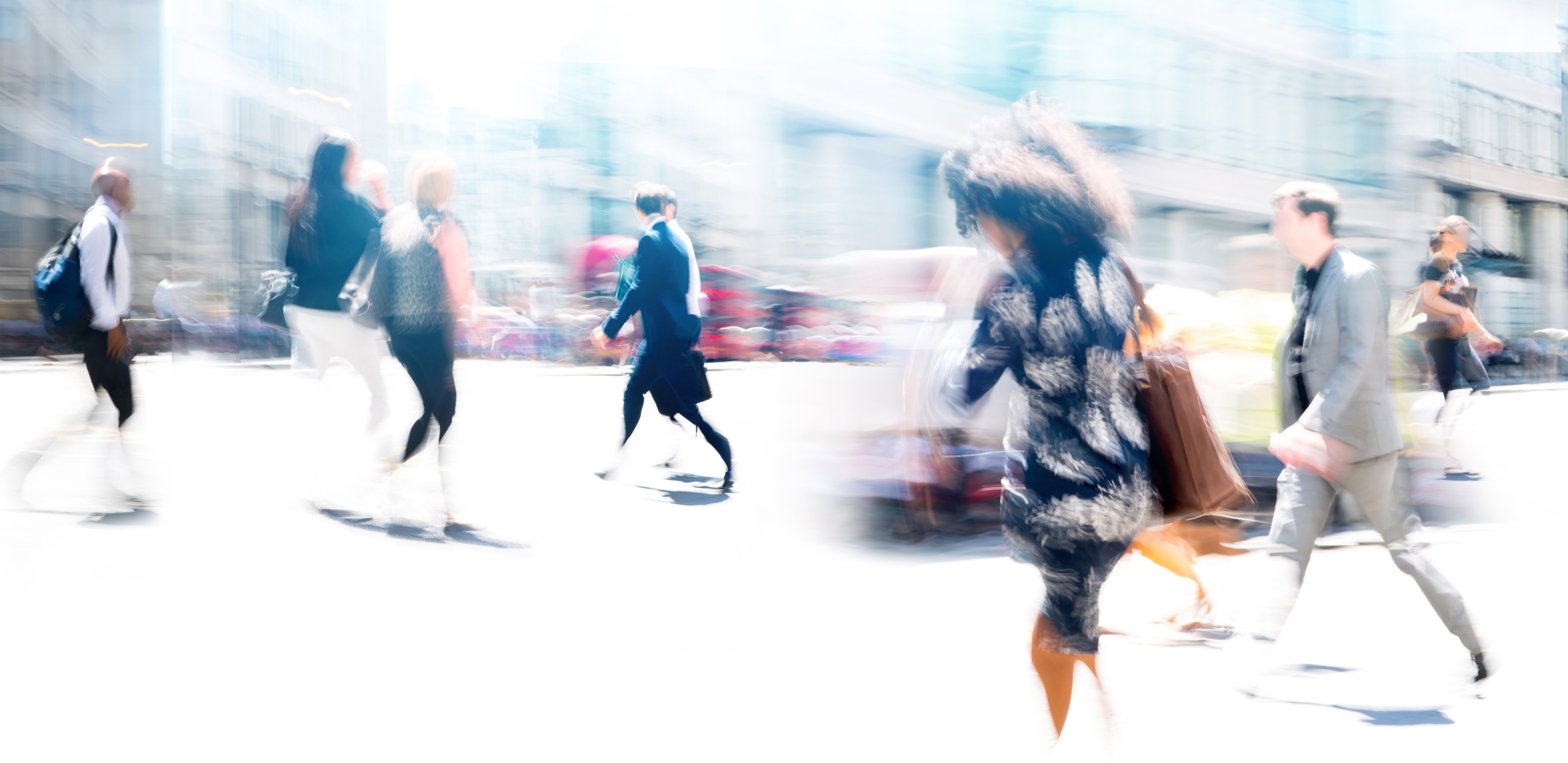 A blurred image of people walking on a busy street.