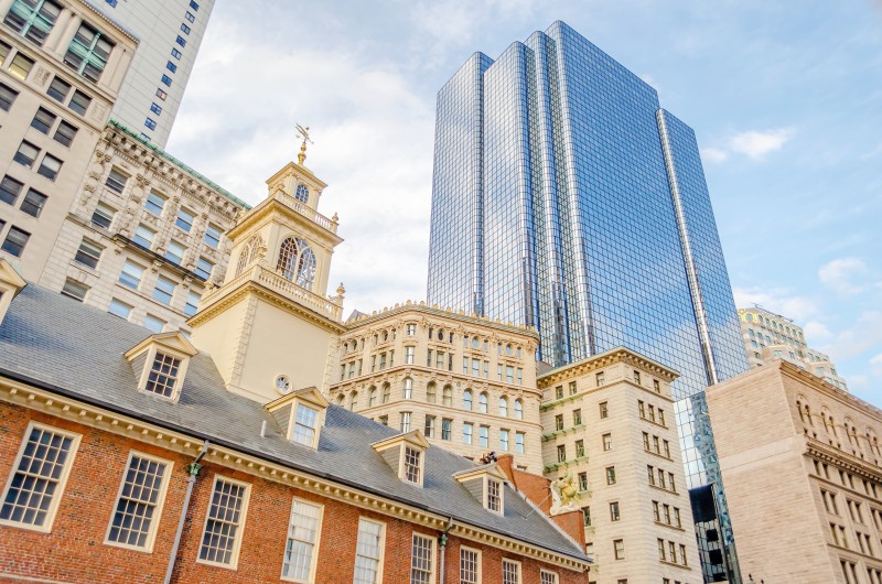 A photo of the Boston old state house with modern buildings in the background.