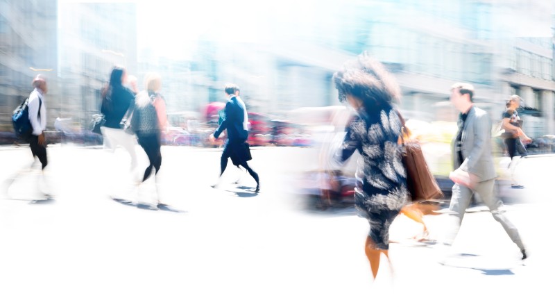 A blurred image of people walking on a busy street.