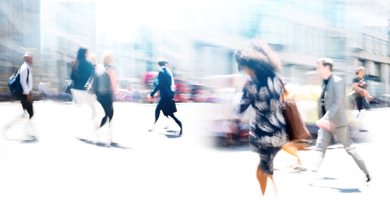 A blurred image of people walking on a busy street.