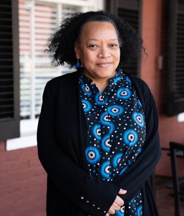 A photo of a person in a blue and black shirt.