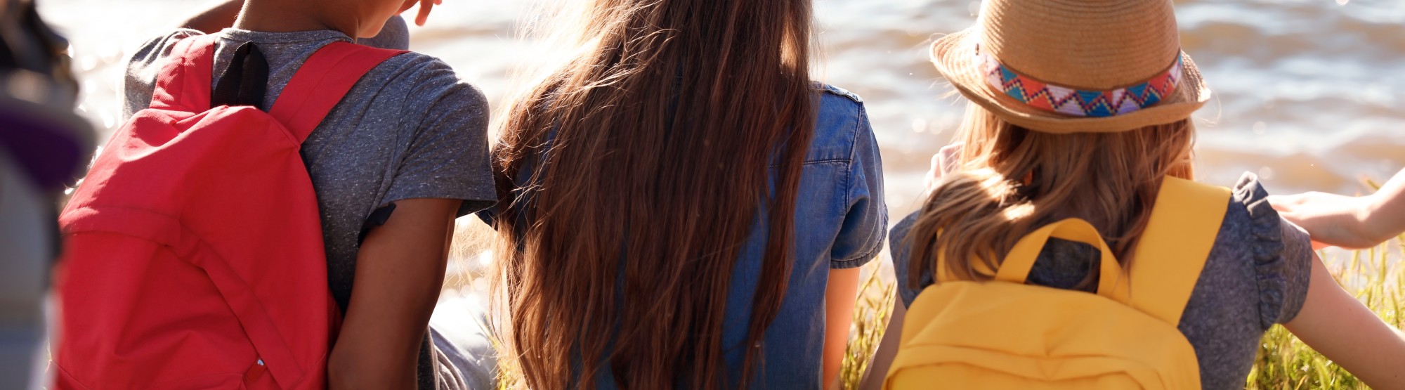 A photo of children sitting by the water.