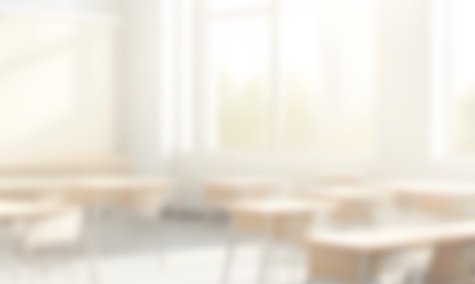 A blurred photo of a sunny classroom with desks and chairs.