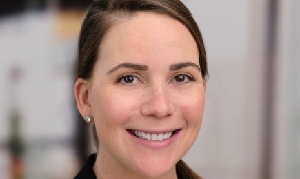 A photo of a person wearing a black blazer and white shirt.