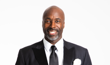 A photo of a person in a black suit.