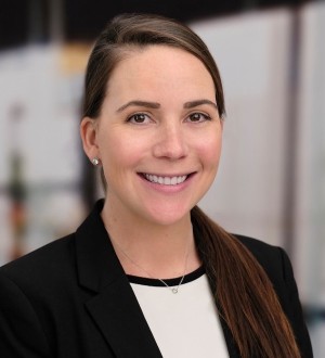 A photo of a person wearing a black blazer and white shirt.